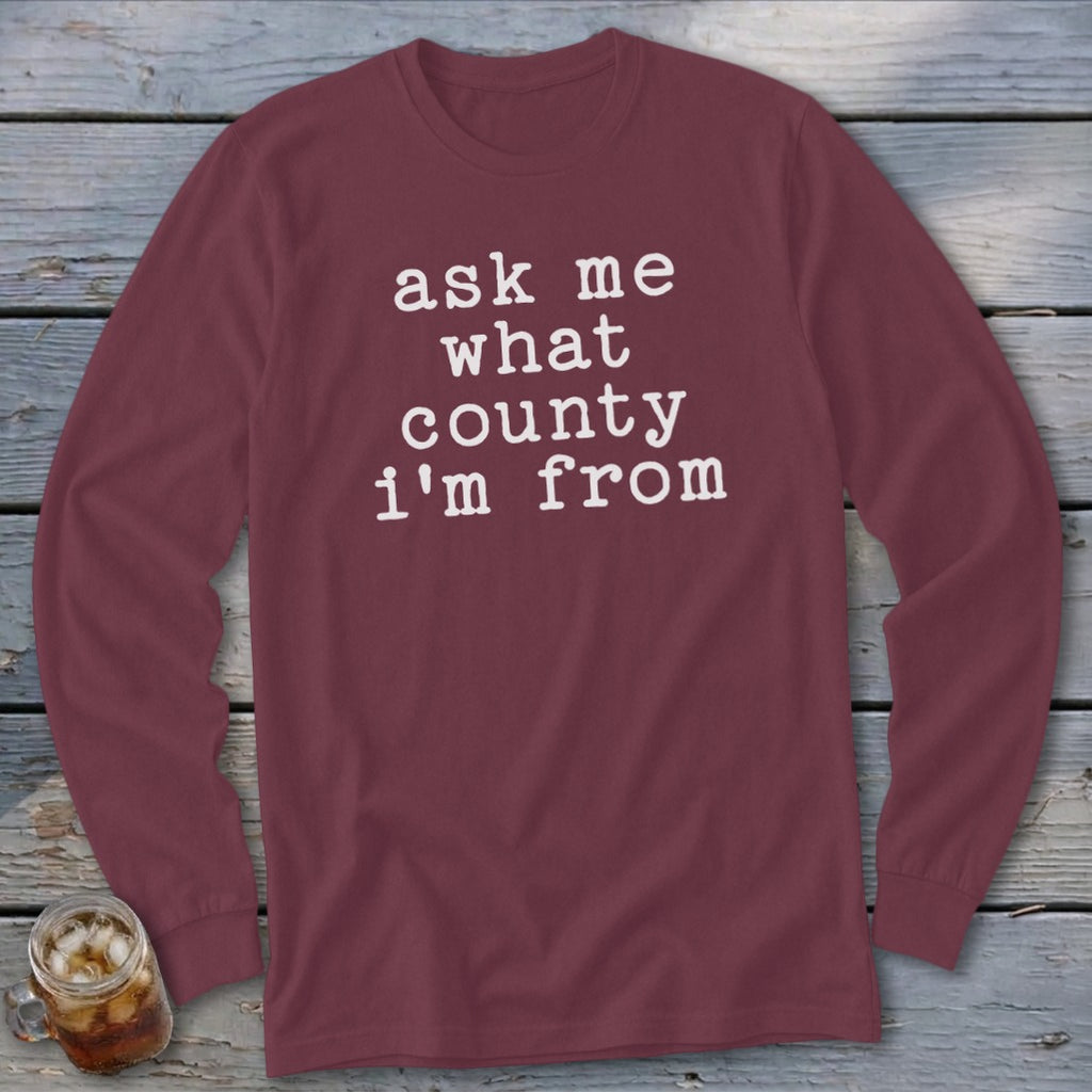 Maroon long-sleeve shirt with white text: "ask me what county i'm from"
