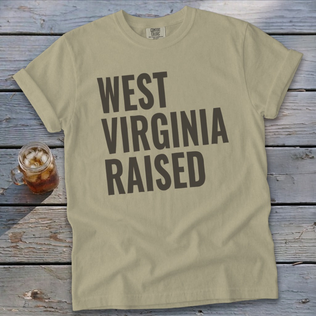 Tan t-shirt with "WEST VIRGINIA RAISED" printed in dark gray text.