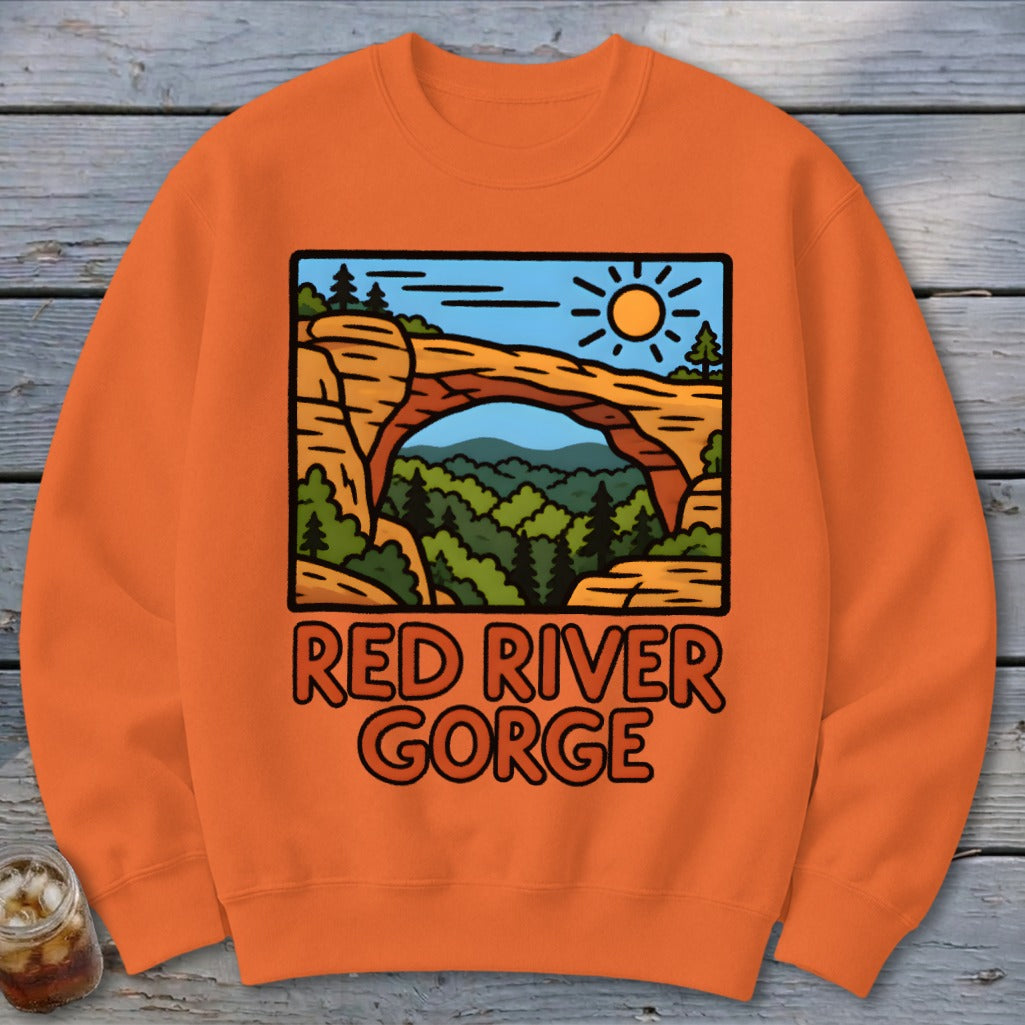 Orange sweatshirt with Red River Gorge graphic featuring natural arch and sun.