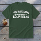 A dark green t-shirt with white text that reads, "THIS THANKSGIVING IS SPONSORED BY SOUP BEANS."