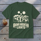 Dark green t-shirt featuring a graphic print of three people looking at glowing lights over mountains, with the text "BROWN MOUNTAIN LIGHTS".