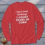 Red long sleeve shirt with white text "I don't count birthdays I count years of corn".