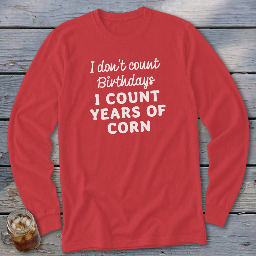 Red long sleeve shirt with white text "I don't count birthdays I count years of corn".