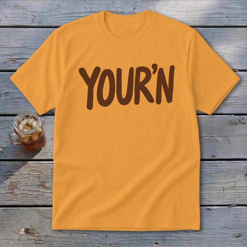 Orange t-shirt with brown "YOUR'N" text, beside a glass of iced beverage.