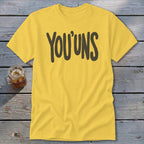 Yellow t-shirt with "YOU'UNS" text and a glass of iced beverage.