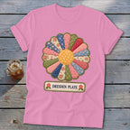 Pink t-shirt with a colorful Dresden Plate fabric flower design and "DRESDEN PLATE" label.