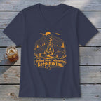 Navy v-neck t-shirt with orange mountain graphic and text "If you hear whistling, keep hiking."