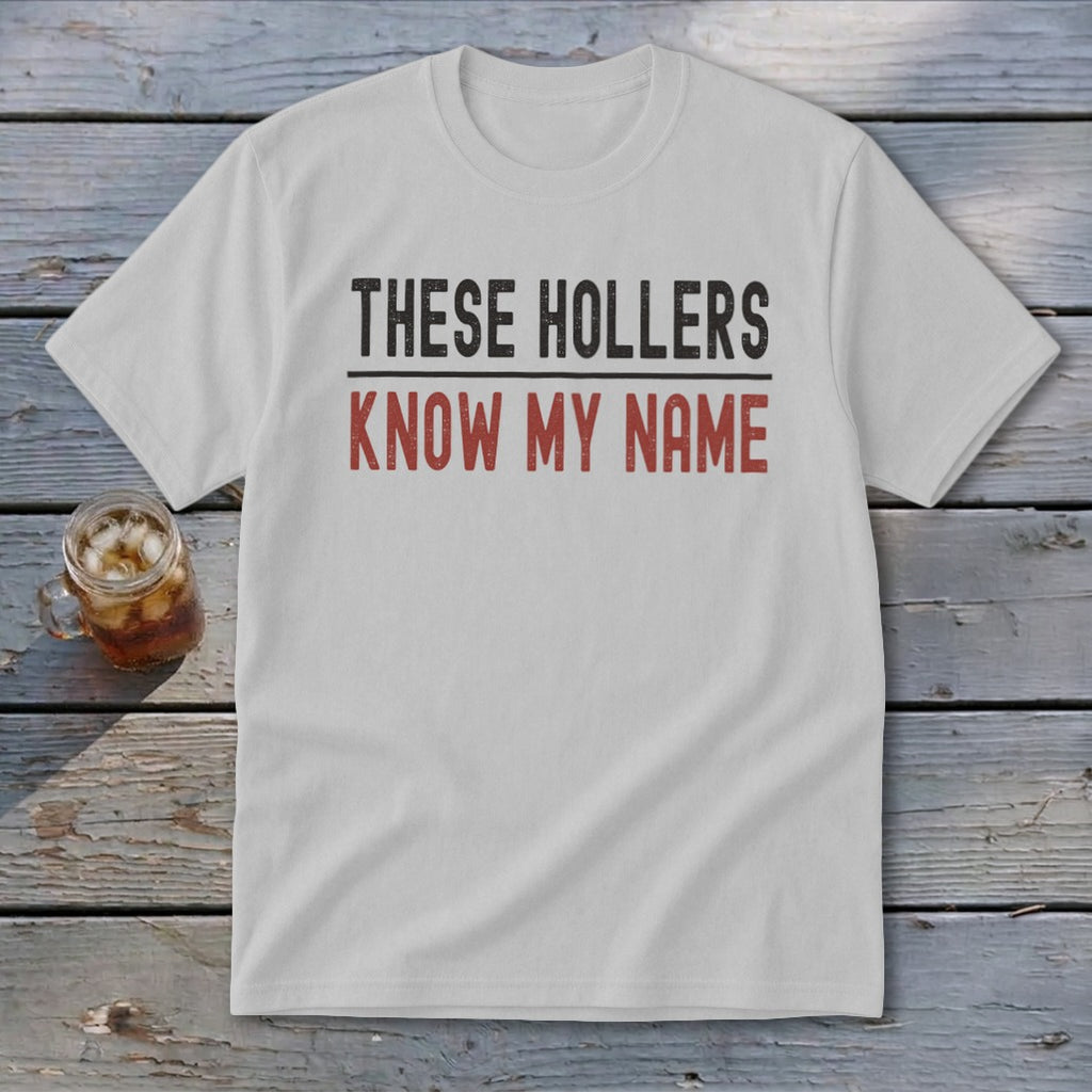 White t-shirt with "THESE HOLLERS KNOW MY NAME" printed in black and red.