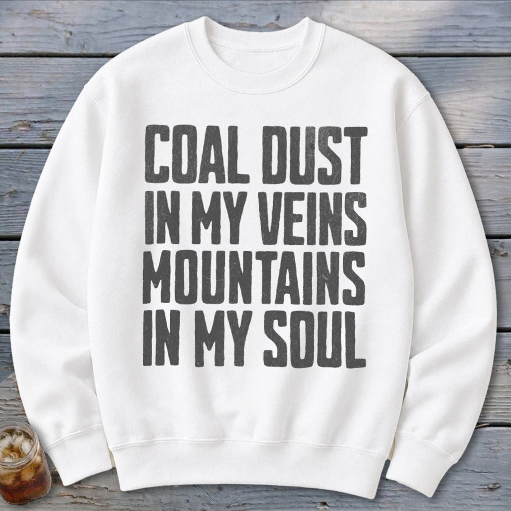 A white crewneck sweatshirt features bold black text reading Coal Dust in My Veins, Mountains in My Soul.