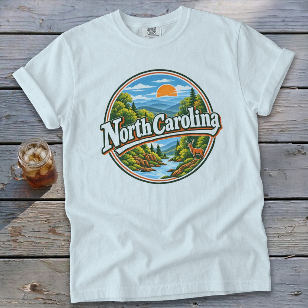 White t-shirt with circular graphic of North Carolina mountains, river, deer, and sun.