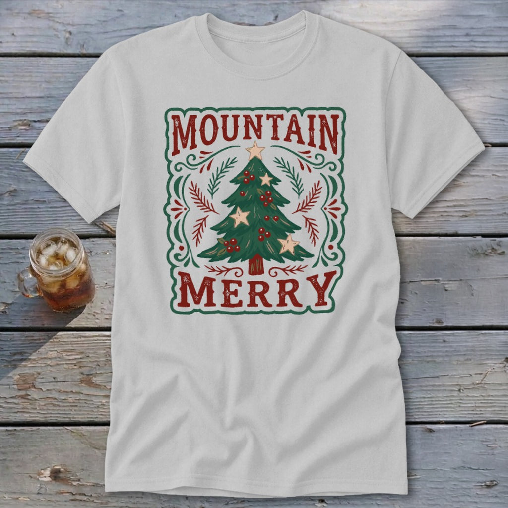 Light gray t-shirt featuring a vintage Christmas tree graphic with the text Mountain Merry on a rustic wooden background.