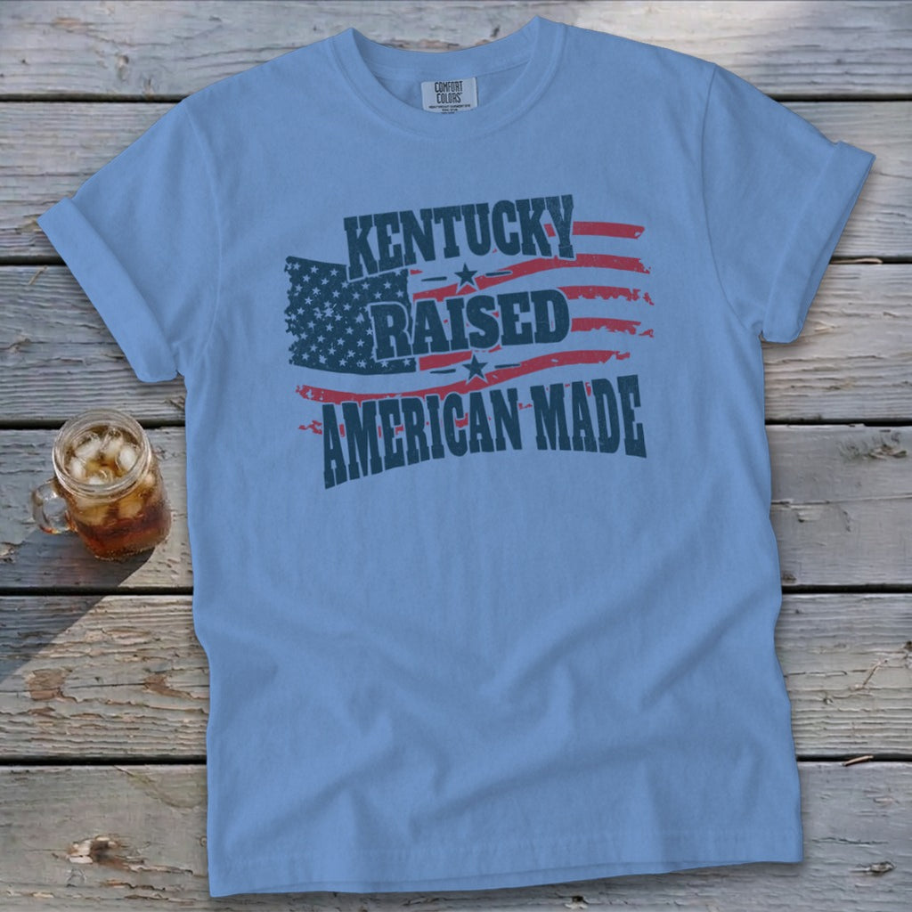 Light blue t-shirt with "Kentucky Raised American Made" text and American flag design.
