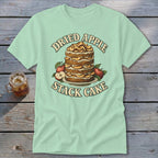 Light green t-shirt with a dried apple stack cake and apples graphic and text.