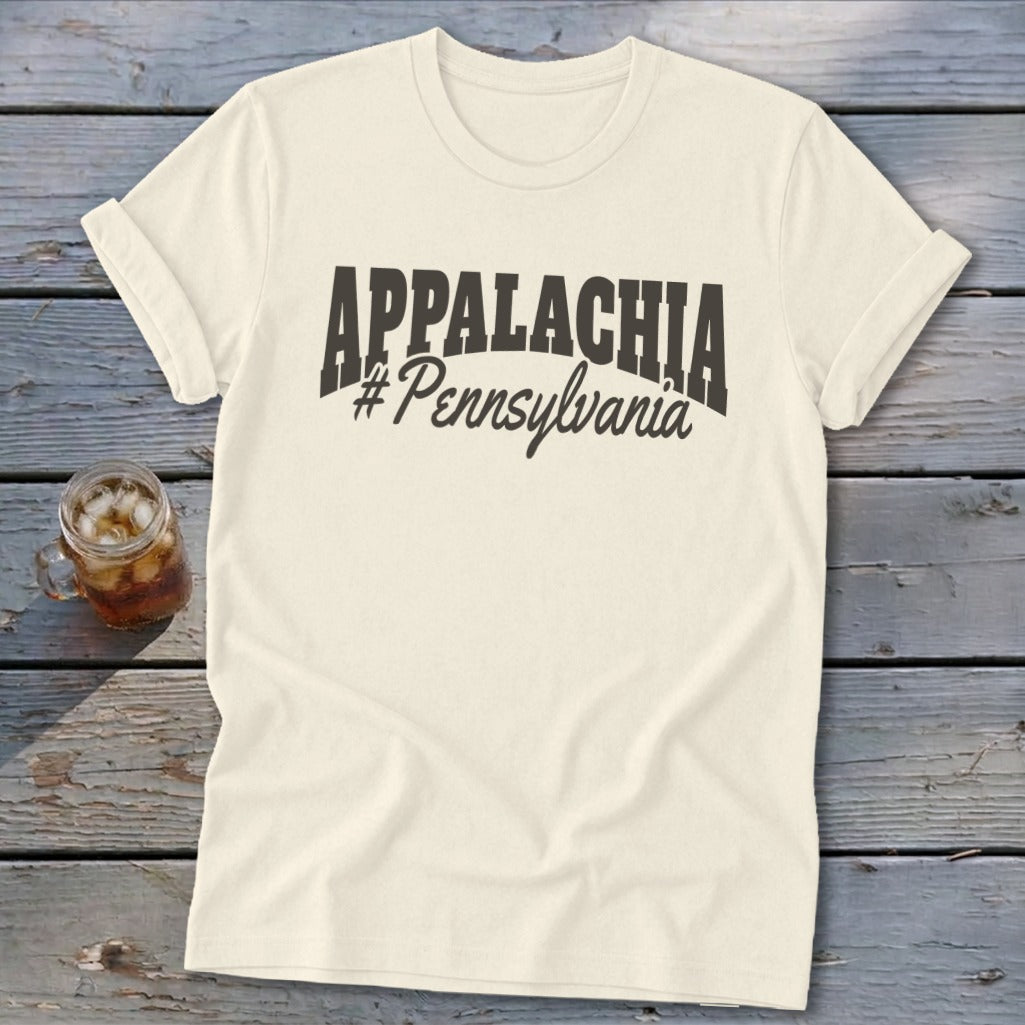 Cream t-shirt with "APPALACHIA #Pennsylvania" text, on wooden surface with drink.