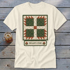 Cream t-shirt with a green, red, and white quilt block design and "BEAR'S PAW" text.