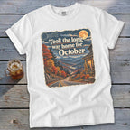 White t-shirt with graphic "Took the long way home for October" and autumn mountain scene.