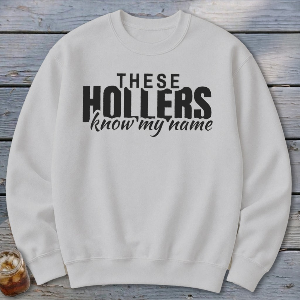 White sweatshirt with "THESE HOLLERS know my name" in black text.