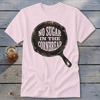 Light pink t-shirt with "NO SUGAR IN THE CORNBREAD" text inside a skillet graphic.