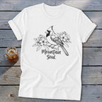White t-shirt with a cardinal and flowers illustration, "Mountain Soul" text.