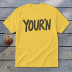 Yellow t-shirt with "YOUR'N" text and a glass of iced drink.