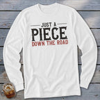 White long sleeve shirt with "JUST A PIECE DOWN THE ROAD" text.