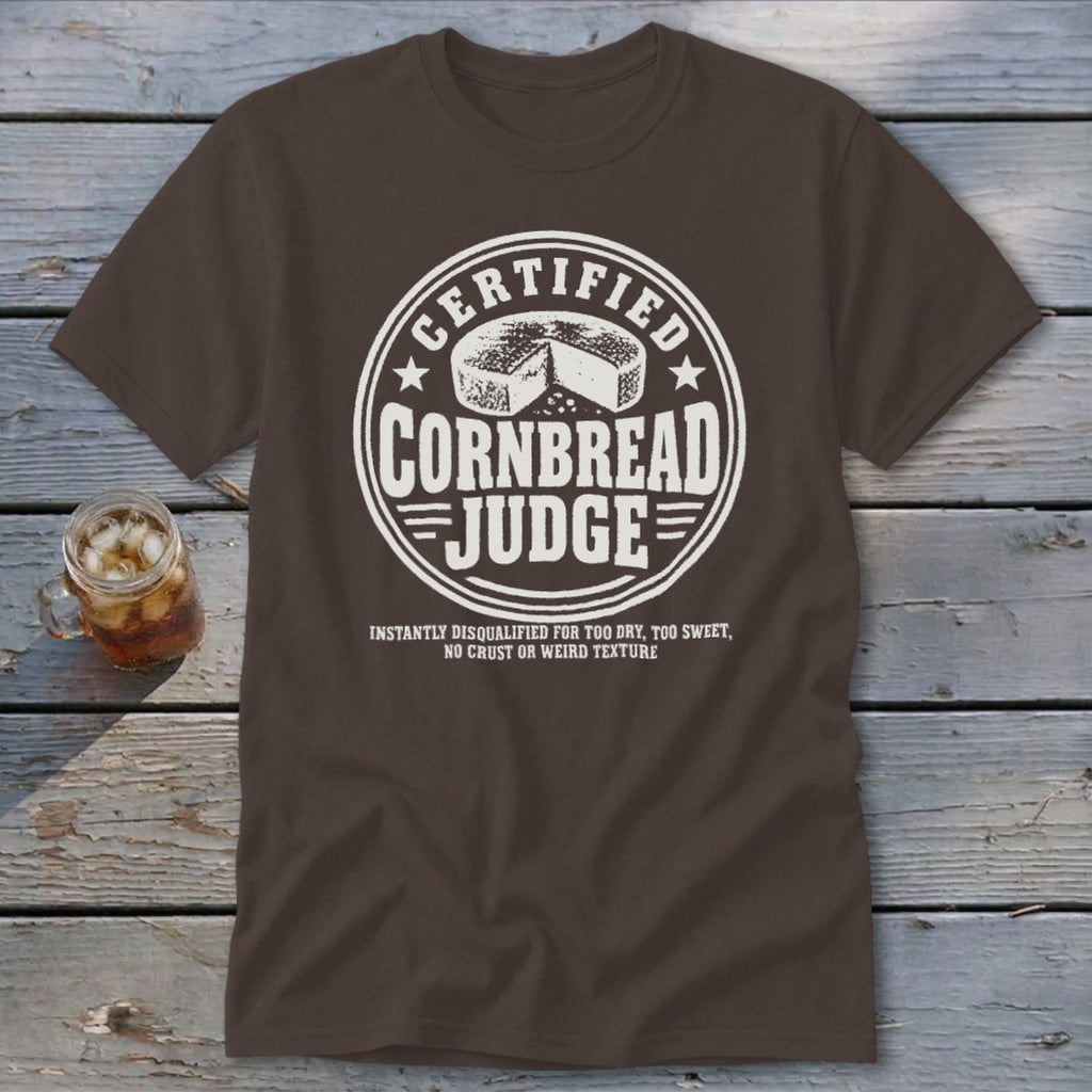 Brown t-shirt featuring a circular white graphic with the text Certified Cornbread Judge and a cornbread illustration.