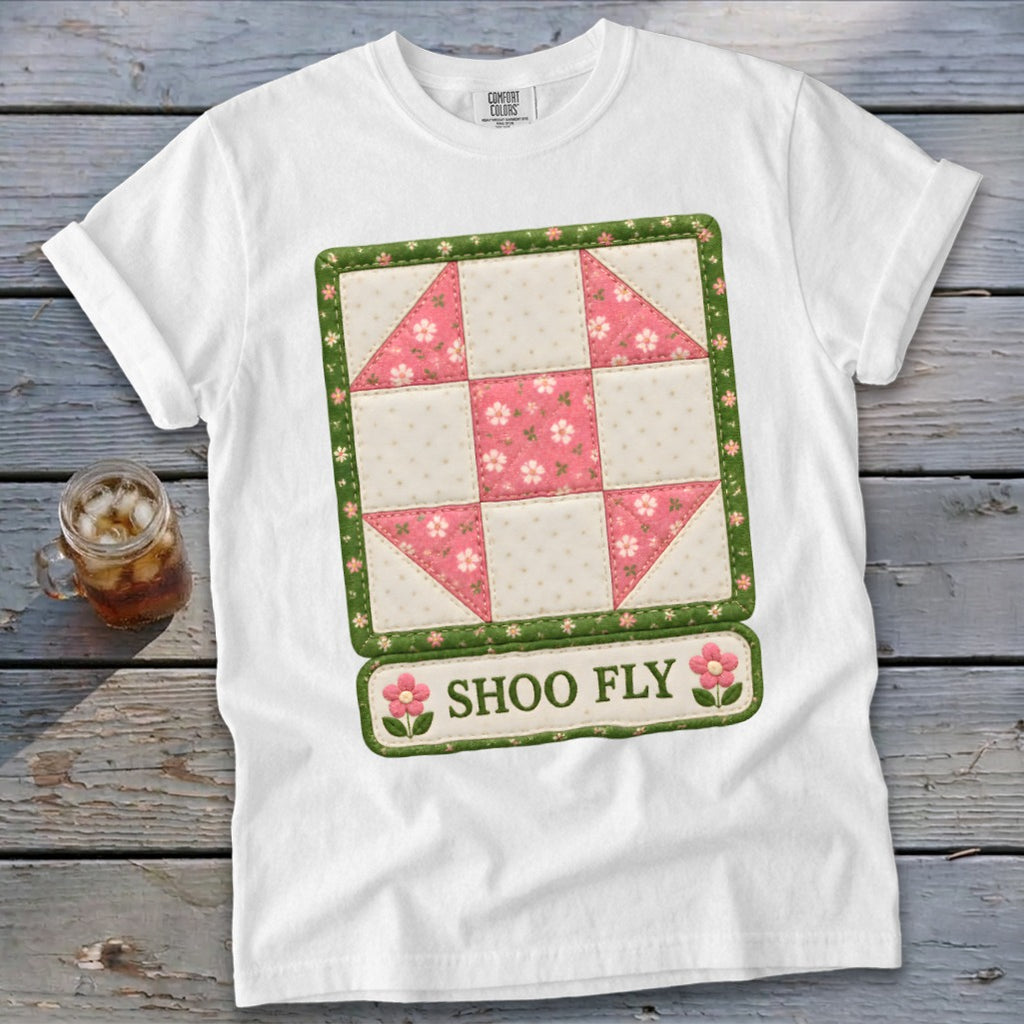 White t-shirt with a "Shoo Fly" quilt block graphic featuring pink floral accents.