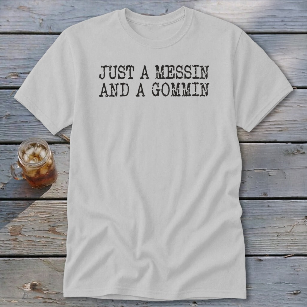 A light gray t-shirt with the text JUST A MESSIN AND A GOMMIN printed in black.
