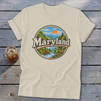 Cream t-shirt with a circular graphic of a Maryland landscape featuring mountains, a river, and a deer.