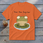 An orange t-shirt featuring a cartoon frog on a lily pad with the text finer than frog's hair.