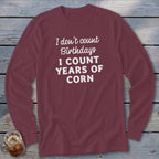 Maroon long sleeve shirt with white text "I don't count Birthdays I COUNT YEARS OF CORN".