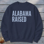 Navy sweatshirt with white text reading "ALABAMA RAISED"