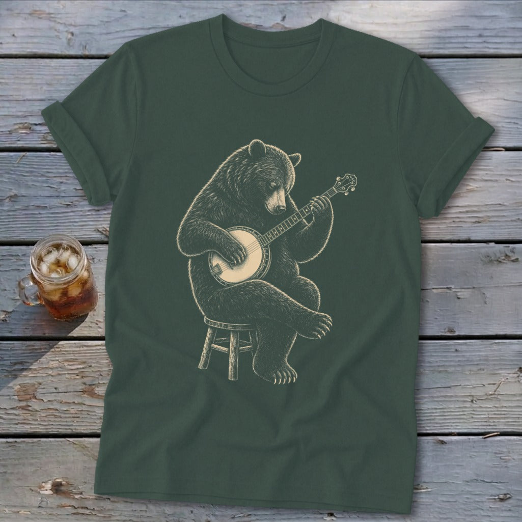 Bear playing a banjo on a stool, graphic on a dark green t-shirt.