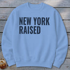 Light blue sweatshirt with "NEW YORK RAISED" printed in dark blue text.