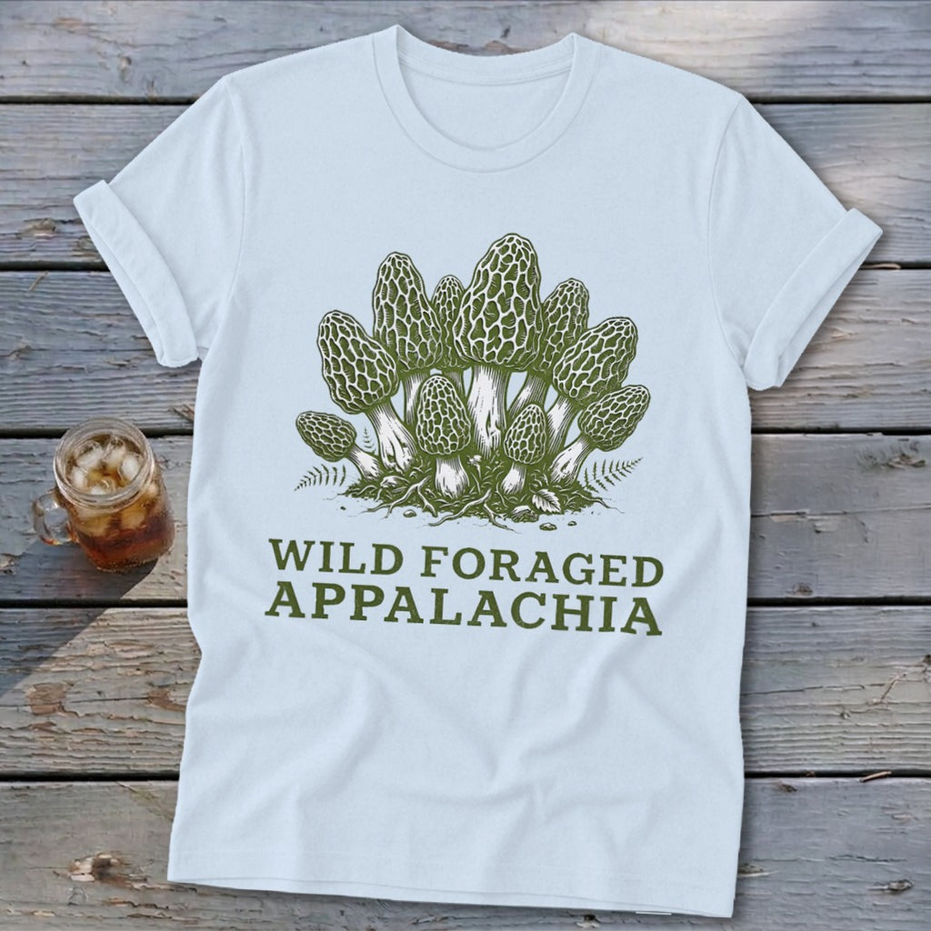 Light blue t-shirt with green illustration of morel mushrooms and text "WILD FORAGED APPALACHIA".