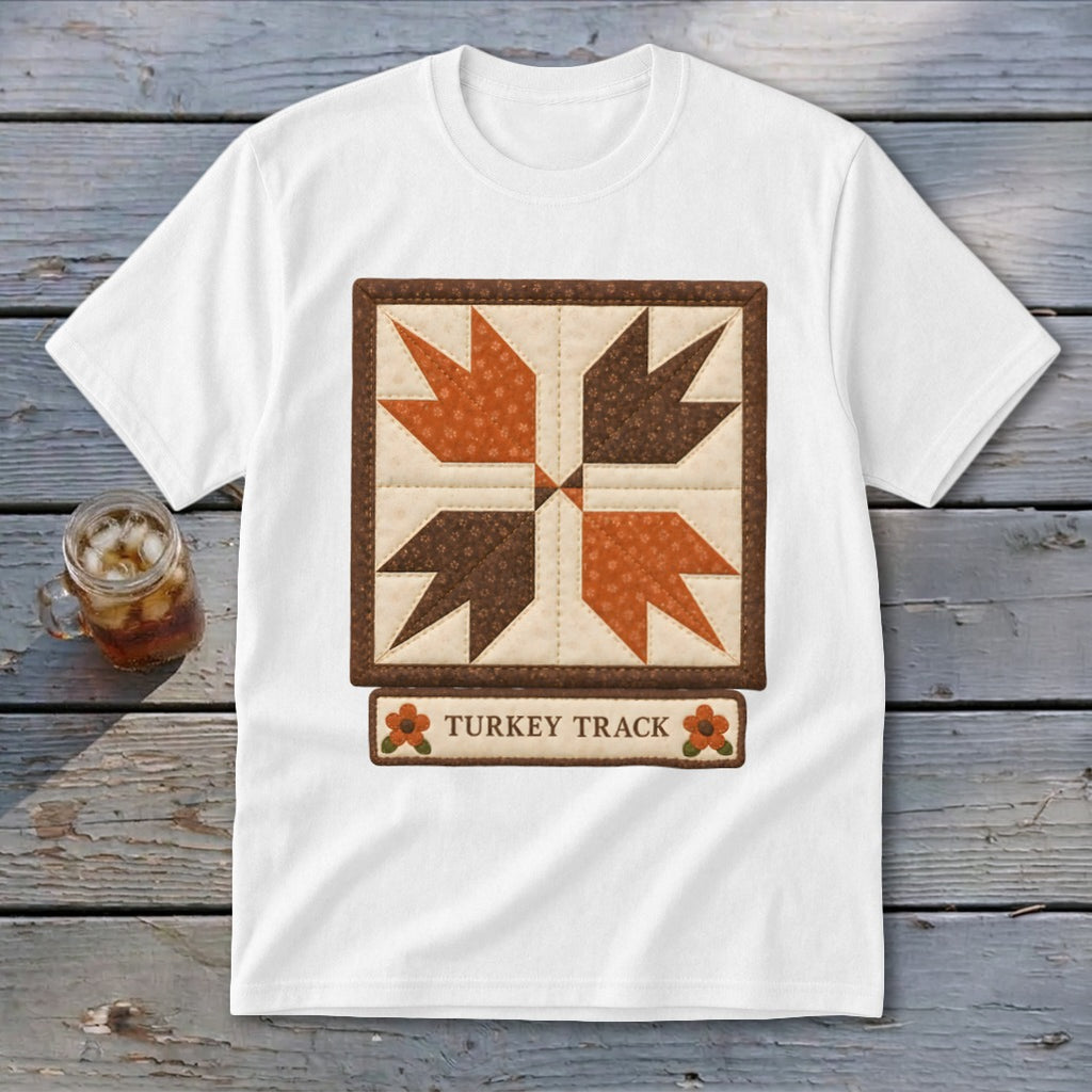 White t-shirt with a quilted "Turkey Track" design and small floral accents.