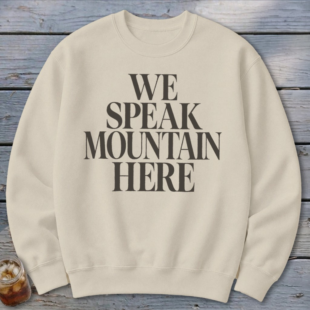 Cream sweatshirt with black text "WE SPEAK MOUNTAIN HERE"