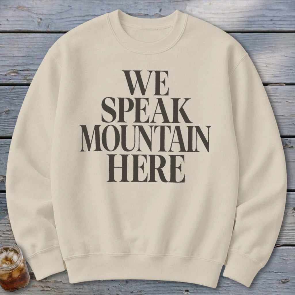 Cream sweatshirt with black text "WE SPEAK MOUNTAIN HERE"