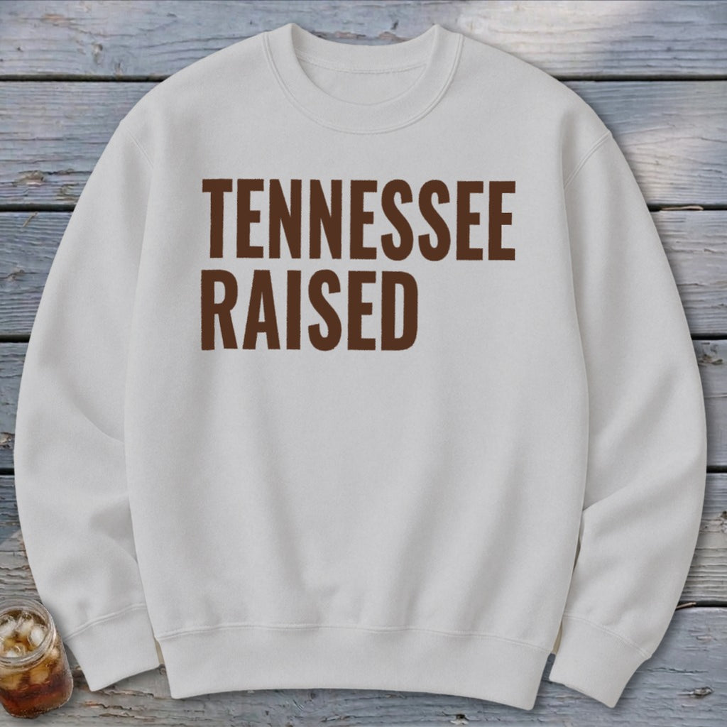 White crewneck sweatshirt with "TENNESSEE RAISED" text in brown.