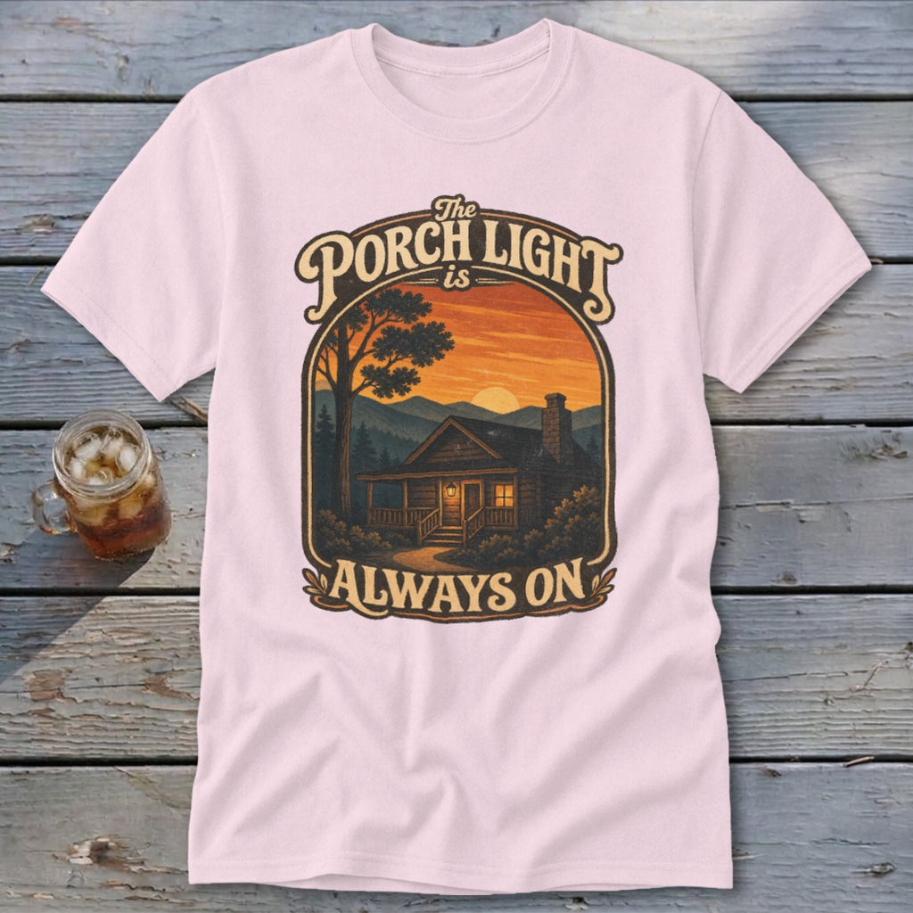 Pink t-shirt with "The Porch Light is Always On" graphic of a cabin at sunset.