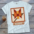 White t-shirt with a quilted maple leaf design and text "MAPLE LEAF".