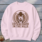 Light pink crewneck sweatshirt with brown graphic of a lantern and text "ESTABLISHED IN THE HILLS".