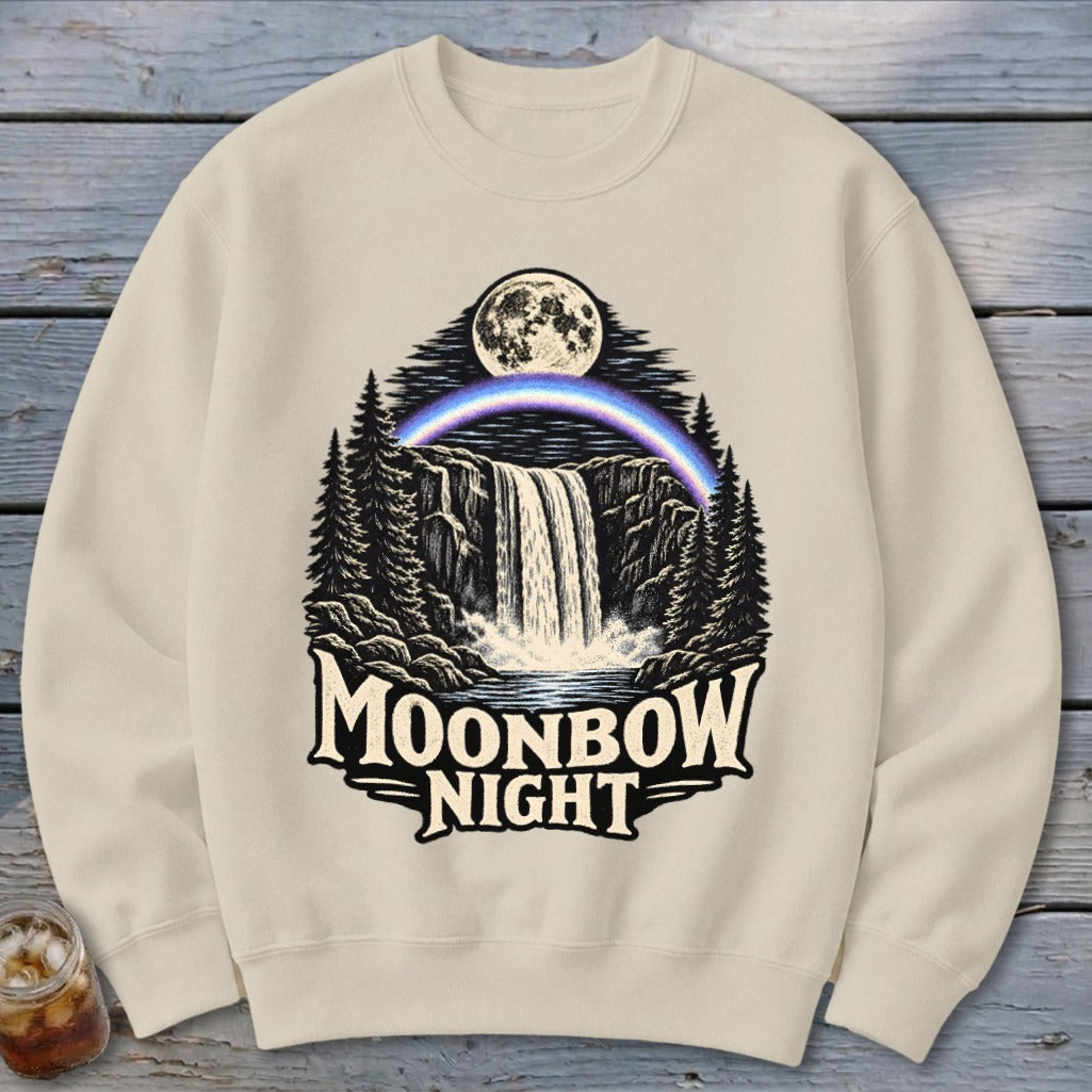Cream sweatshirt with Moonbow Night waterfall, moon, and rainbow graphic.