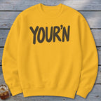 Yellow crewneck sweatshirt with "YOUR'N" printed in dark brown.