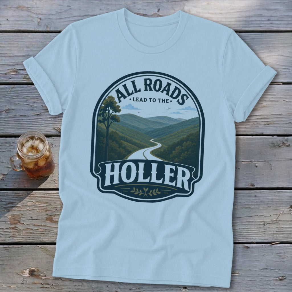 Light blue t-shirt with a graphic of a winding road through mountains and "All Roads Lead to the Holler."