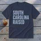 Navy t-shirt with light blue text reading "SOUTH CAROLINA RAISED".