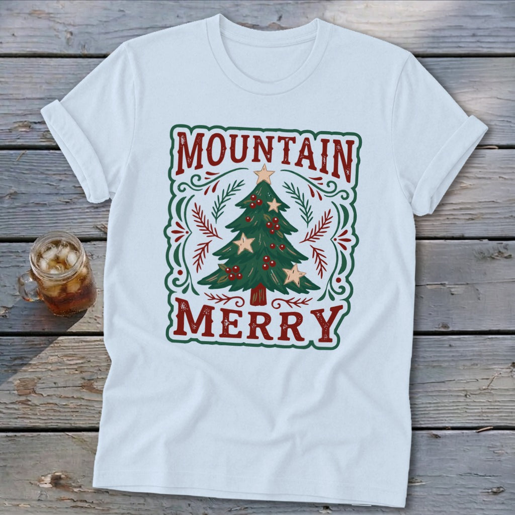 White short-sleeved t-shirt featuring a green and red Christmas tree design with the text Mountain Merry.