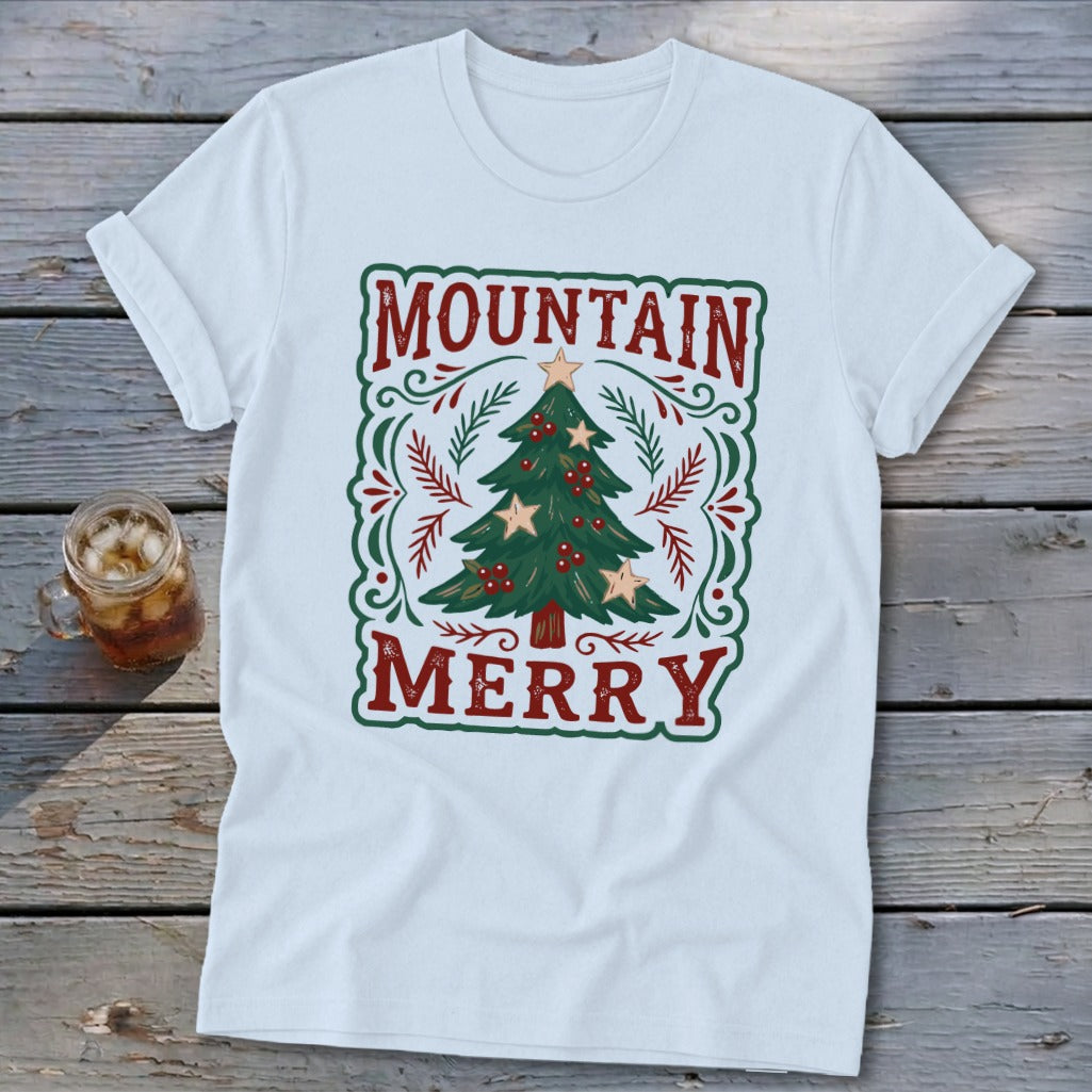 White short-sleeved t-shirt featuring a green and red Christmas tree design with the text Mountain Merry.