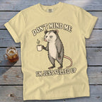 Light yellow t-shirt with opossum holding coffee and text "Don't mind me I'm just sulled up".