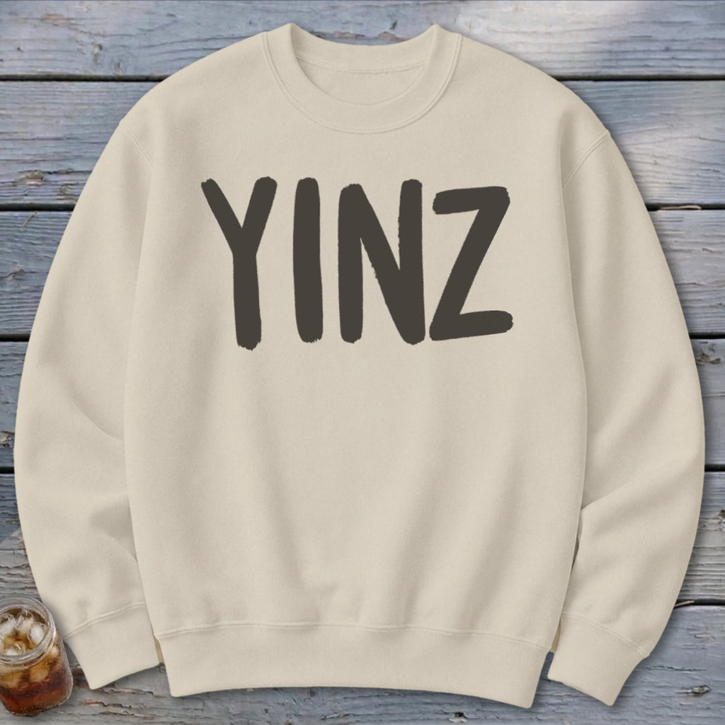 Cream sweatshirt with dark gray "YINZ" text across the chest.